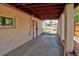 Covered carport featuring exposed wood beam ceiling and concrete flooring next to a doorway with white trim at 1560 Simms St, Lakewood, CO 80215