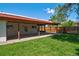 Backyard featuring a covered patio, gravel landscaping, and a verdant lawn, offering a private retreat for outdoor enjoyment at 1560 Simms St, Lakewood, CO 80215