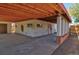 Spacious covered patio featuring a concrete floor and exposed wood beams, perfect for outdoor living and entertaining at 1560 Simms St, Lakewood, CO 80215