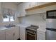 Compact kitchen featuring white cabinets, stainless steel appliances, and ample countertop space at 1560 Simms St, Lakewood, CO 80215