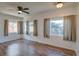 Bright living room featuring hardwood floors, a ceiling fan, and multiple windows for ample natural light at 1560 Simms St, Lakewood, CO 80215