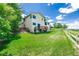 Expansive backyard with lush lawn, wooden deck, and partial fencing under a bright blue sunny sky at 551 Snowy Owl Pl, Highlands Ranch, CO 80126