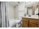 Clean bathroom features a tub-shower, white tile, and wooden vanity with a sink at 551 Snowy Owl Pl, Highlands Ranch, CO 80126