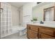Cozy bathroom featuring a shower-tub combo, tile surround, and a single sink vanity with wood cabinets at 551 Snowy Owl Pl, Highlands Ranch, CO 80126