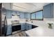 Bright kitchen with stainless steel appliances, stone countertops, a window, and blue cabinets at 551 Snowy Owl Pl, Highlands Ranch, CO 80126