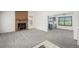 Open concept living room with fireplace leading into dining area with modern blue cabinets and a large window at 551 Snowy Owl Pl, Highlands Ranch, CO 80126