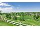 Scenic neighborhood with a baseball field, green spaces, and houses nestled among the trees with a wooden fence at 551 Snowy Owl Pl, Highlands Ranch, CO 80126
