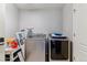 Laundry room with modern washer and dryer, plus storage for cleaning supplies at 23593 E Chenango Pl, Aurora, CO 80016