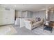 Comfortable living room featuring a neutral sofa, gray carpet, and bright natural light at 23593 E Chenango Pl, Aurora, CO 80016