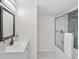 Updated bathroom featuring modern vanity, decorative floors, and a bathtub with sliding glass door at 1130 Orchard St, Golden, CO 80401