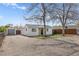 A house with a detached garage and a fenced yard under a bright sunny sky at 1130 Orchard St, Golden, CO 80401