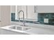 Modern kitchen sink with pull down faucet and white countertops and accent backsplash at 1130 Orchard St, Golden, CO 80401