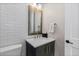 Elegant powder room with white tile, dark vanity, and stylish bronze fixtures at 10113 Bellwether Ln, Lone Tree, CO 80124