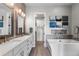 This luxurious bathroom features a double sink vanity, a soaking tub, and a walk-in closet at 10113 Bellwether Ln, Lone Tree, CO 80124