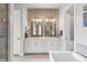 This well-lit bathroom has a double sink vanity, soaking tub and a walk-in shower at 10113 Bellwether Ln, Lone Tree, CO 80124