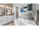 This bathroom includes a soaking tub, double sink vanity and decoratively tiled walls at 10113 Bellwether Ln, Lone Tree, CO 80124