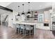 Modern kitchen with an island, bar seating, stainless steel appliances, floating shelves, and stylish brick backsplash at 10113 Bellwether Ln, Lone Tree, CO 80124