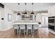 Bright, modern kitchen features an island with seating, white cabinets, and brick backsplash at 10113 Bellwether Ln, Lone Tree, CO 80124