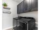 Well-equipped laundry room with dark cabinetry and stainless steel washer and dryer set at 10113 Bellwether Ln, Lone Tree, CO 80124