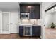 Modern wet bar with sleek cabinetry, wine fridge, stainless steel microwave, and sink at 10113 Bellwether Ln, Lone Tree, CO 80124