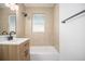 Updated bathroom with modern vanity, tub, and tiled walls at 1151 Xanthia St, Denver, CO 80220