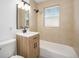 Modern bathroom with a new vanity, a bathtub with tile surround, and upgraded fixtures at 1151 Xanthia St, Denver, CO 80220