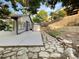 Landscaped backyard featuring stone pathway, concrete patio, and storage shed at 12375 Ivy Pl, Brighton, CO 80602