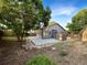 Private backyard with concrete patio, mature trees, and storage shed at 12375 Ivy Pl, Brighton, CO 80602