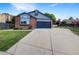 Charming single-Gathering home featuring a brick facade, gray siding, manicured lawn, and a convenient two-car garage at 12375 Ivy Pl, Brighton, CO 80602