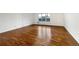 The empty living room features newly refinished hardwood floors, neutral paint, and a large window at 12375 Ivy Pl, Brighton, CO 80602
