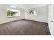 The empty bedroom features neutral paint, newly installed carpet, and large windows for ample natural light at 12375 Ivy Pl, Brighton, CO 80602