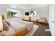 This bedroom is staged with light-colored furniture, a large bed, carpet, and features a large window at 12375 Ivy Pl, Brighton, CO 80602
