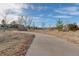 Curving concrete pathway through a grassy area with trees at 20697 E Lake Ave, Centennial, CO 80016