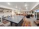 Basement game room featuring a ping pong table, leather furniture, and a wet bar at 1995 Wingfeather Ln, Castle Rock, CO 80108