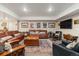 Basement living area with multiple leather couches, patterned rugs, and a flat screen TV at 1995 Wingfeather Ln, Castle Rock, CO 80108