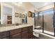 Bathroom vanity with granite countertop and a walk-in shower with glass doors at 1995 Wingfeather Ln, Castle Rock, CO 80108