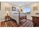 Cozy bedroom with wood floors, a patterned rug, wooden bed frame, and bright window at 1995 Wingfeather Ln, Castle Rock, CO 80108