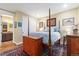 Bedroom with hard wood floors, white closet doors, and a four post bed frame at 1995 Wingfeather Ln, Castle Rock, CO 80108