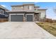 Contemporary two-story home with a three-car garage, stone accents, and spacious concrete driveway at 1995 Wingfeather Ln, Castle Rock, CO 80108