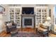 Inviting living room with cozy fireplace, bespoke bookshelves, and comfortable leather seating at 1995 Wingfeather Ln, Castle Rock, CO 80108