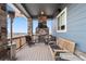 Relaxing outdoor covered deck with stone fireplace, heater, and comfortable seating area at 1995 Wingfeather Ln, Castle Rock, CO 80108