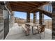 Covered outdoor patio area with stone columns and outdoor dining set at 1995 Wingfeather Ln, Castle Rock, CO 80108