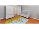 Bright Bedroom featuring hardwood floors, a crib, and plenty of storage at 2311 W 46Th Ave, Denver, CO 80211