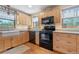 View of kitchen with wood cabinets, black appliances, and a corner sink at 2311 W 46Th Ave, Denver, CO 80211