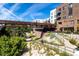 Scenic view of a walkway and buildings featuring lush greenery and a charming bridge at 20 Wilcox St # 318, Castle Rock, CO 80104