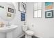 Stylish powder room with a pedestal sink, modern toilet, and decorative artwork at 126 S Vandriver Way, Aurora, CO 80018