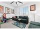 Cozy bedroom with a green sofa, a ceiling fan, and decorative posters at 126 S Vandriver Way, Aurora, CO 80018