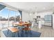 Bright dining area with a wood table and chairs, opening to a modern kitchen with white cabinetry at 126 S Vandriver Way, Aurora, CO 80018