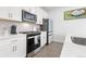 Bright kitchen featuring white cabinets, stainless steel appliances, and modern fixtures at 126 S Vandriver Way, Aurora, CO 80018