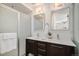 Bright bathroom featuring a double vanity, framed mirrors, modern lighting, and a glass shower at 3389 Cranston Cir, Highlands Ranch, CO 80126
